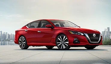 2023 Nissan Altima in red with city in background illustrating last year's 2022 model in Hubler Nissan in Indianapolis IN