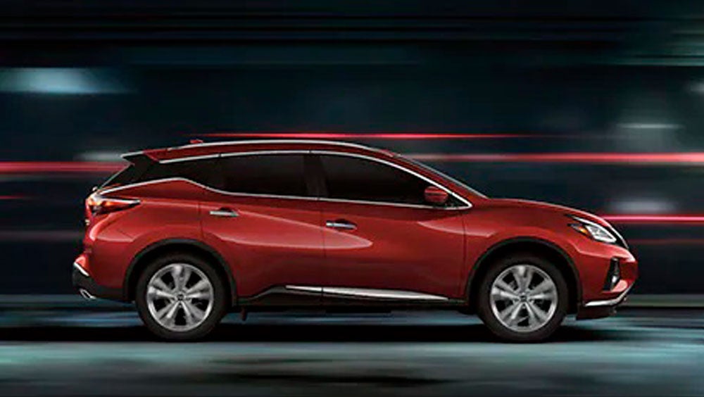 2023 Nissan Murano shown in profile driving down a street at night illustrating performance. | Hubler Nissan in Indianapolis IN